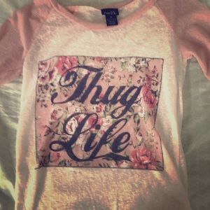 A white and peach shirt with thug life on front
